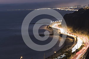 highway with a lot of traffic in the green crust very close to the beaches of miraflores - at night aerial view peru