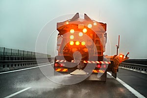 Highway maintenance gritter truck spreading de icing salt on road