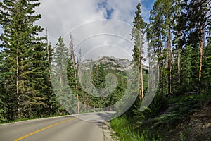 Highway in mountains. Transportation. Landscape rocks, sunny sky with clouds, Banff, Alberta, Canada