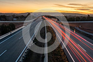 On a highway, red light trails of the cars only in one direction and there is no traffic in the opposite direction