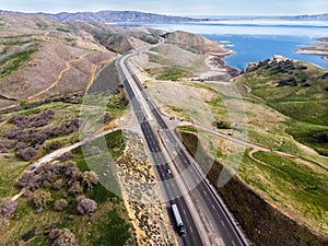 Highway scenic interstate asphalt road with cars and trucks at scenic mountain area and ocean