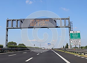 Highway sign indicating the prohibition to use the mobile phone while driving is a sign that says to always have snow chains on photo