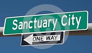 Highway sign with SANCTUARY CITY and ONE WAY