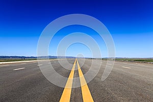 Highway in steppe against a blue sky