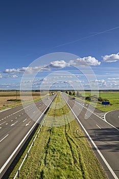 Highway to horizons with small traffic at warm summer day evening