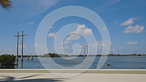 Highway to Key West Florida. View of old abandoned bridge and coast line of Atlantic ocean on blue sky.