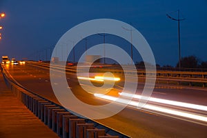 Highway traffic cars at night blured. Cars moving on road on bridge evening blurry.