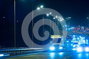 Highway traffic cars at night blured. Cars moving on road on bridge evening blurry.