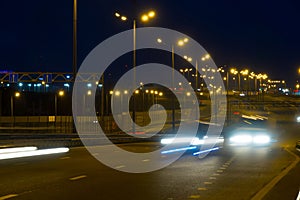 Highway traffic cars at night blured. Cars moving on road on bridge evening blurry.