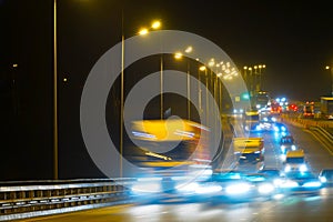 Highway traffic cars at night blured. Cars moving on road on bridge evening blurry.