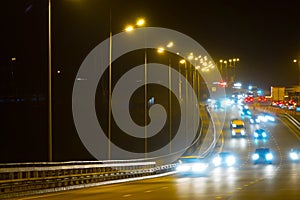 Highway traffic cars at night blured. Cars moving on road on bridge evening blurry.