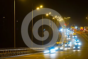 Highway traffic cars at night blured. Cars moving on road on bridge evening blurry.