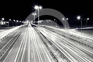 Highway traffic at night. Cars lights in motion.