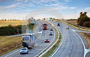 Highway traffic in sunset with cars and trucks