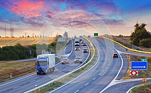 Highway traffic in sunset with cars and trucks photo