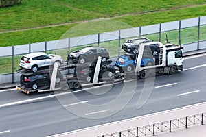 Highway transportation of new cars on a trailer with a truck for delivery to dealers photo