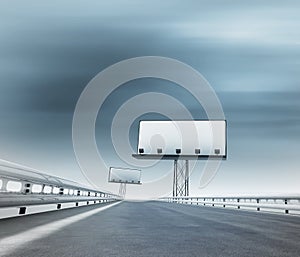 Highway with two billboards afar with blurred sky