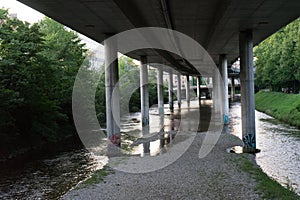 Highway underpass from concrete with small river