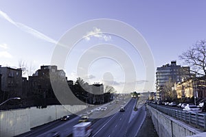 Highway view from above with speeding cars and apartment buildings in the background