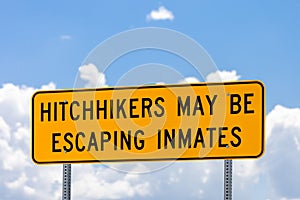 Highway warning sign about hitchhikers that might be escaping in