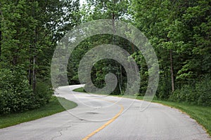 Highway winding and twisting through lush green forest.