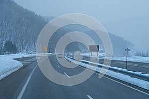 Highway in wintertime or Winter road in a blizzard