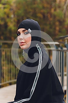 Hijab girl exercising on walkway bridge in early morning. Muslim woman wearing sports clothes doing stretching workout