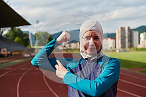 A hijab woman in a burqa showing her boldness by showing her muscles on her arms