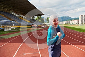 A hijab woman in a burqa showing her boldness by showing her muscles on her arms