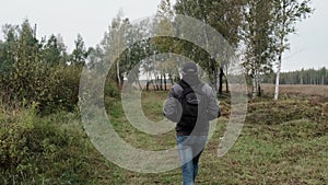 Hike with a knapsack in the autumn forest. Adult  man with backpack in fall forest nature