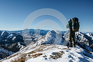 hiker admiring view from snowy mountaintop, clear sky