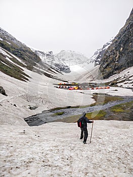 Hiker approaching campsite on a glacier after hard day of hiking