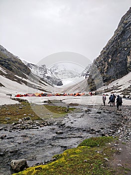 Hiker approaching campsite on a glacier after hard day of hiking