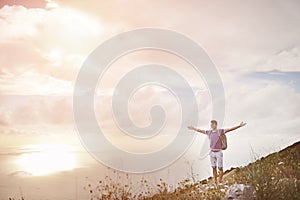 Hiker with arms wide open on top of a mountain - freedom conquest concept