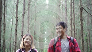 Hiker Asia backpacker couple on hiking adventure feeling freedom walking in forest.