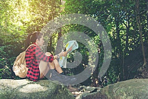 Hiker asian woman backpack walking trail activity camping outdoors and checking map for destination leisure