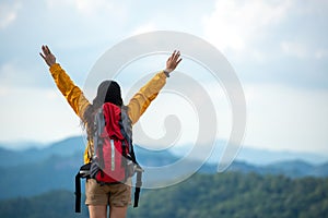 Hiker asian women raise hand and pointing happy feeling freedom good and strong weight victorious facing on the natural mountain.