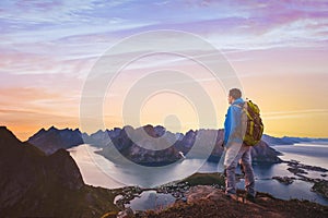 Hiker with backpack enjoying sunset landscape in Lofoten, Norway