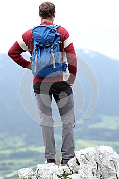 Hiker with backpack is standing on top