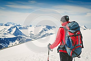 Hiker with backpack standing on top and enjoying tne view