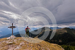 Hiker with backpack standing on top of a mountain