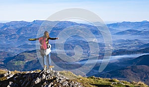 Hiker with backpack standing on top of the mountain