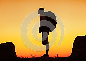 Hiker with backpack standing on top of a mountain