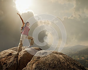 Hiker with backpack standing on top of a mountain