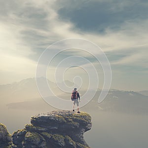 Hiker with backpack standing on top of a mountain