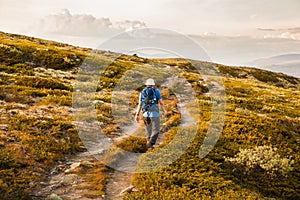 Hiker with backpack traveling in Norway mountains Dovre