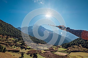 Hiker backpacker man using trekking poles showing on Thamserku 6608m mountain during high altitude Acclimatization walk. Everest