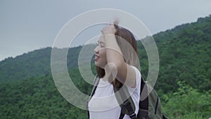 Hiker backpacker woman on hiking adventure feeling freedom walking in forest near lake in rainy day.