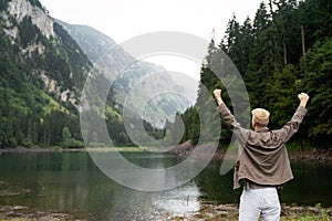 Hiker with backpacks reaches the summit of mountain peak. Success, freedom and happiness concept