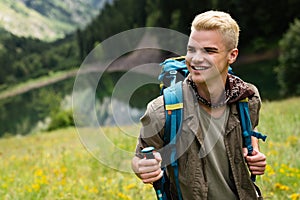 Hiker with backpacks reaches the summit of mountain peak. Success, freedom and happiness concept